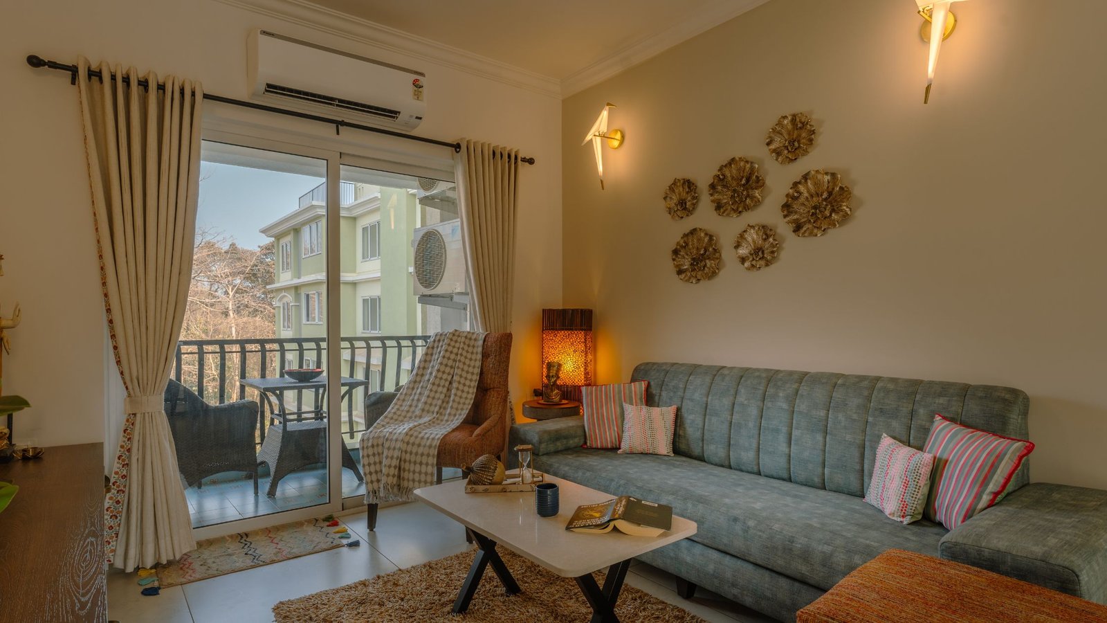 Second home interior design in Goa. Cozy living room with a teal sofa